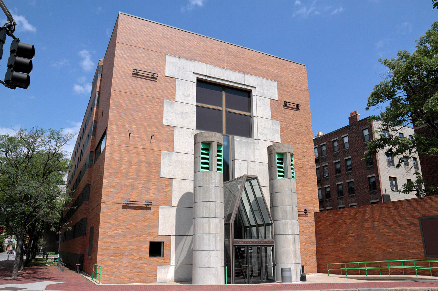 Brick frontage of building, with monumental columns either sice of the glass-covered entrance