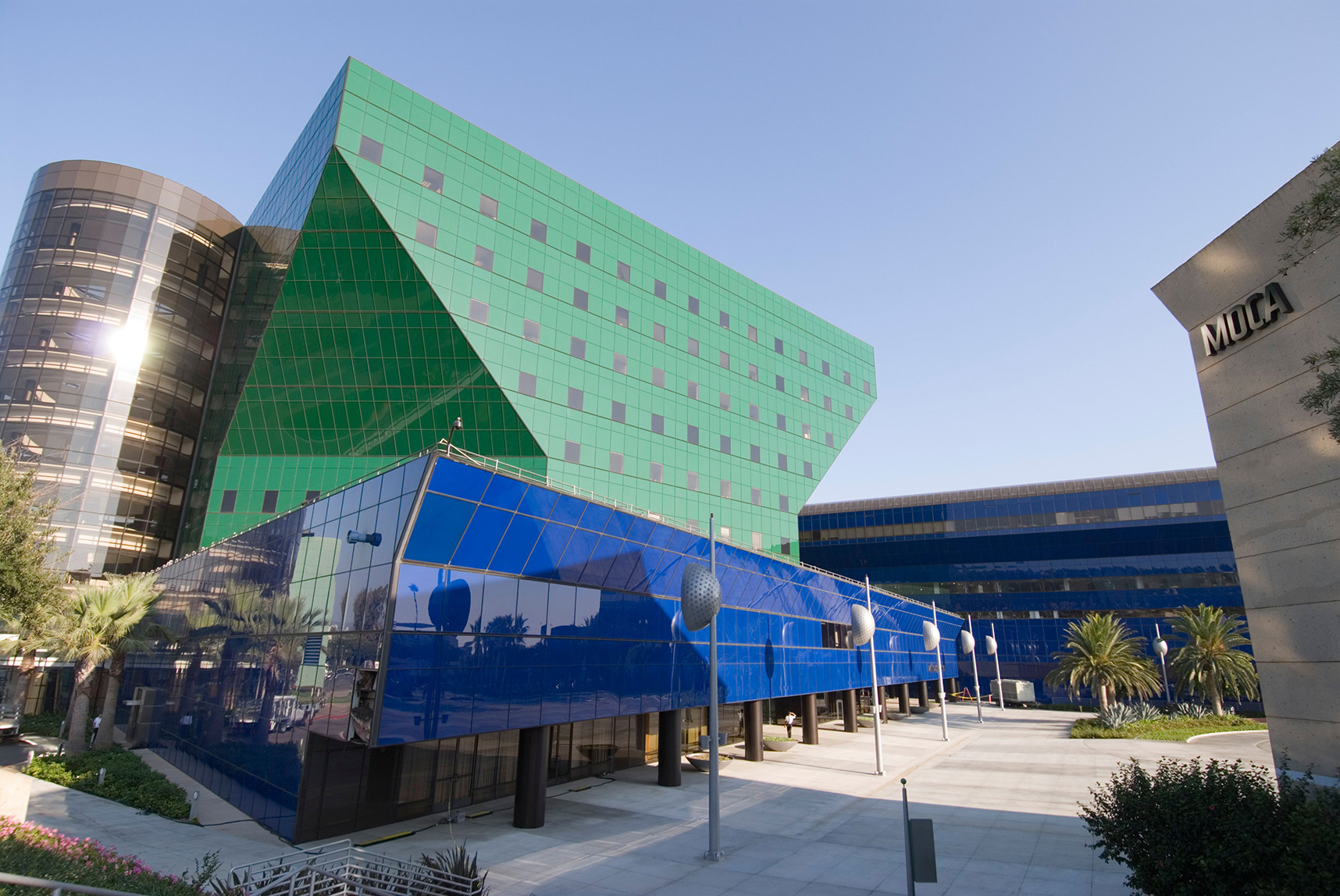 Large blue-green funnel-shaped building, with a bright blue base